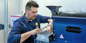 Barista expertly roasting specialty coffee at Garage Coffee Bros. with a Giesen coffee roaster.