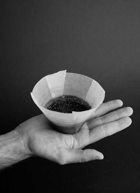 Sibarist FLAT flat-bottom coffee filter held in hand showing smooth ungrooved design