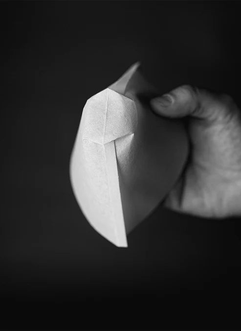 Folded Sibarist FLAT 2 zero-bypass coffee filter showing precise creases and texture