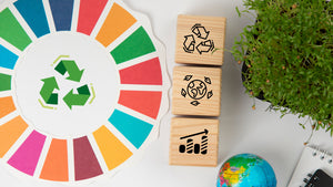 Colorful recycling wheel with wooden blocks featuring eco-icons and a globe, promoting sustainability and environmental awareness.