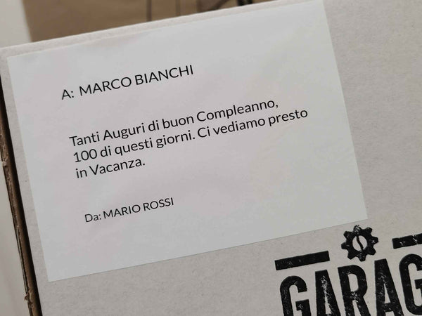 Messaggio di auguri stampato e adesivo su scatola con testo di auguri di compleanno da Mario Rossi a Marco Bianchi.